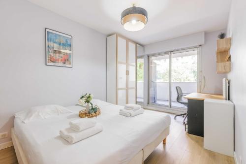 une chambre blanche avec un lit avec des serviettes dessus dans l'établissement Authentic apartment - 3BR-8P - La Villette, à Paris