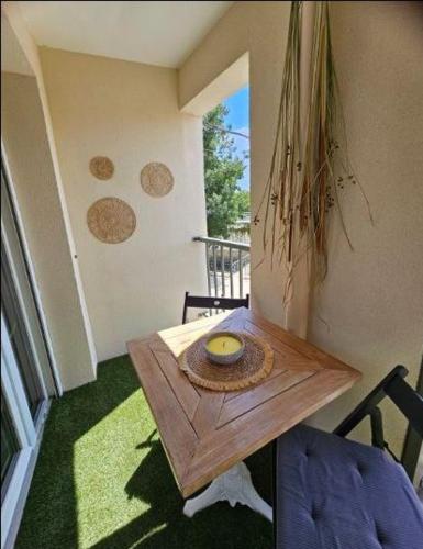 - un balcon avec une table et un bol dans l'établissement Au petit coeur de l'isle, à LʼIsle-sur-la-Sorgue