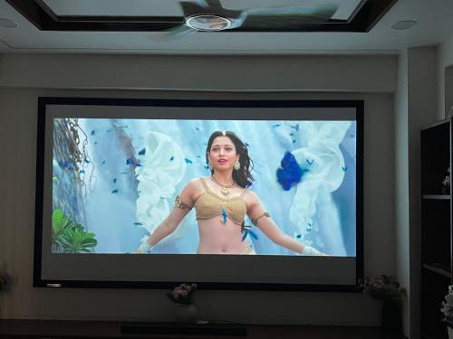 a television screen with a woman in a bikini on it at Atlas Homes 1BHK HomeStays in Hyderabad