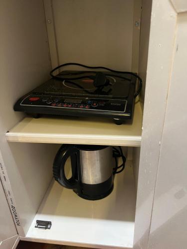 a coffee maker and a coffee mug on a shelf at Atlas Homes 1BHK HomeStays in Hyderabad