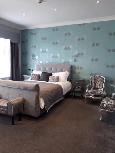 a bedroom with a large bed and a chair at canterbury lodge in Kent