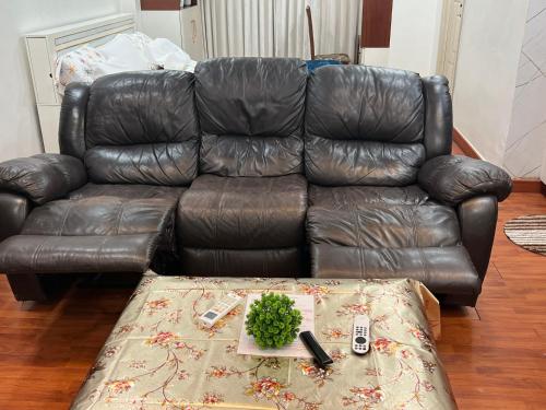 a leather couch in a living room with a table at Atlas Homes 1BHK HomeStays in Hyderabad