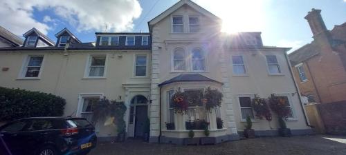 a white house with a car parked in front of it at canterbury lodge in Kent