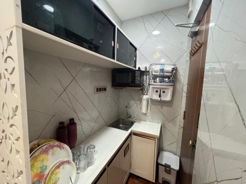 a small kitchen with a sink and a microwave at Atlas Homes 1BHK HomeStays in Hyderabad