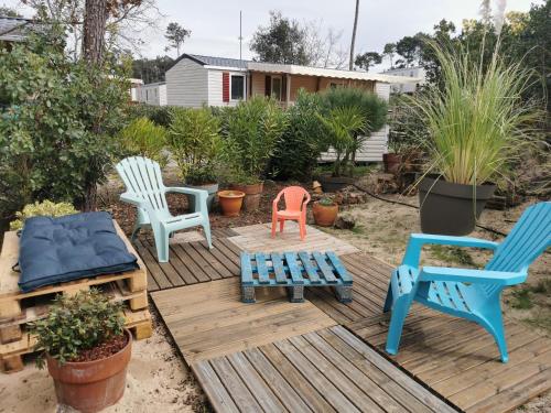 un groupe de chaises assises sur une terrasse en bois dans l'établissement Mobile home le Savannah, à Lège-Cap-Ferret