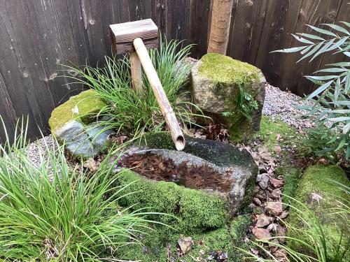 a garden with a baseball bat on a rock at 清水寺徒歩8分 一棟貸切 伝統的な京町家 in Keage
