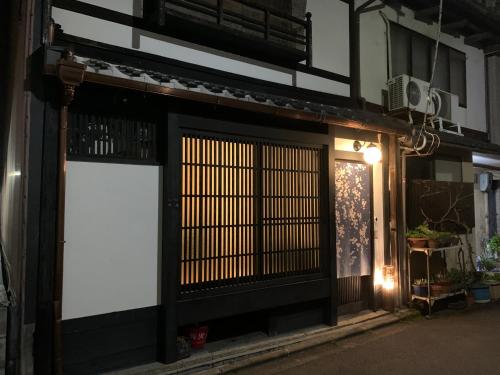 a building with a white sign in front of a door at 清水寺徒歩8分 一棟貸切 伝統的な京町家 in Keage