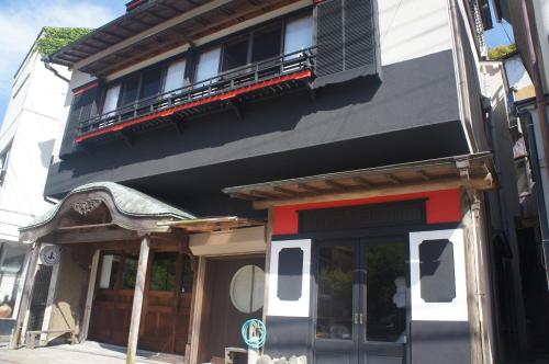 a building with a balcony on top of it at 宿坊かつら in Izu