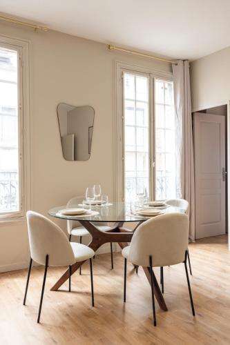 une salle à manger avec une table et des chaises en verre dans l'établissement Appartement spacieux & paisible aux porte de Paris, à Le Pré-Saint-Gervais