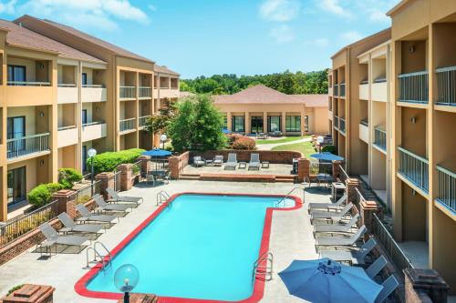 an image of a pool at a hotel with chairs and umbrellas at Courtyard by Marriott Little Rock West in Little Rock