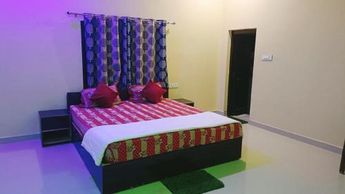 a bedroom with a bed with purple and red pillows at The Mountain View Home Stay in Khajurāho