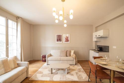 un salon avec un canapé et une table dans l'établissement Appartement chaleureux près de Paris, à Le Pré-Saint-Gervais