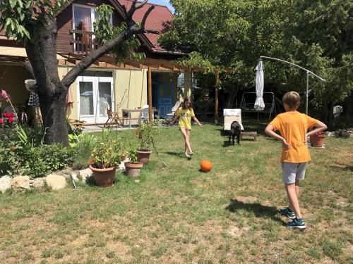 two children playing with an orange ball in a yard at 4 Guests: River & Garden Charm in Budapest