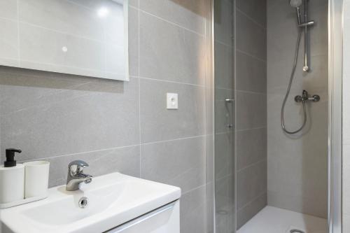 une salle de bain avec un lavabo et une douche dans l'établissement Appartement chaleureux près de Paris, à Le Pré-Saint-Gervais
