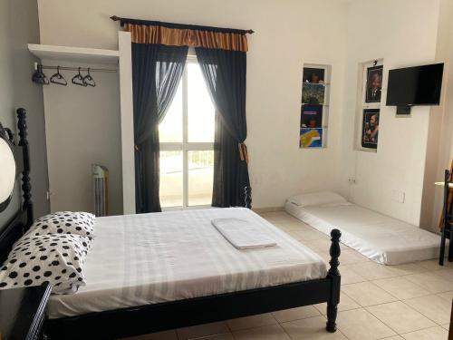 a bedroom with two beds and a window at Nha Casa Porto Novo in Porto Novo