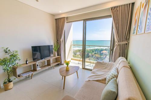 a living room with a couch and a large window at The Song Luxury Vung Tau Apartment - QUỲNH's Homestay in Vung Tau