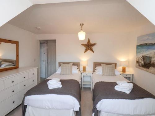 a bedroom with two beds and a mirror at Adventure Cottage in Whitby