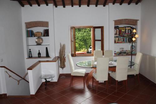 a dining room with a table and white chairs at Il casale di Sandra in Chiusi