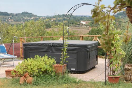 a black hot tub sitting on a patio with plants at Il casale di Sandra in Chiusi