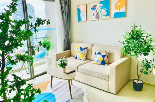 a living room with a couch and potted plants at The Song Luxury Vung Tau Apartment - QUỲNH's Homestay in Vung Tau