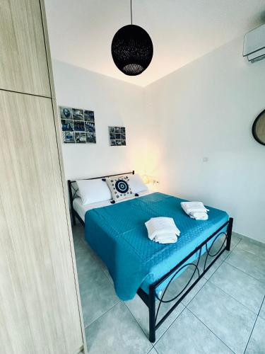 a bedroom with a blue bed in a room at Poppis Apartments in Ierapetra