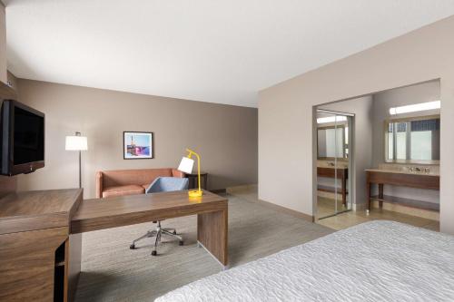 a hotel room with a desk and a couch at Hampton Inn & Suites Harrisburg in Harrisburg
