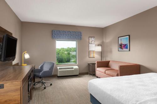a hotel room with a bed a desk and a chair at Hampton Inn & Suites Harrisburg in Harrisburg