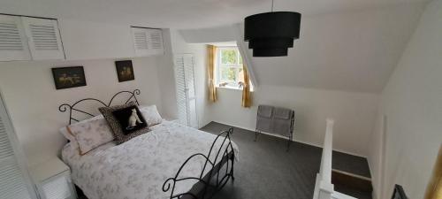 a white bedroom with a bed and a window at Charming Lincoln Cottage Family & Pet-Friendly in Lincoln