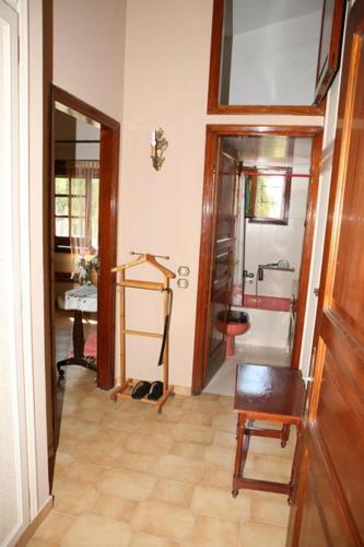 a hallway with a room with a mirror and a chair at Cosy Villa in Pikérmion