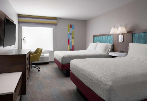 a hotel room with two beds and a flat screen tv at Hampton Inn San Diego/Del Mar in San Diego