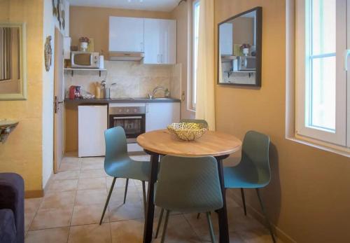 une cuisine avec une table et des chaises dans une pièce dans l'établissement Le Forum Quartier La Roquette, à Arles