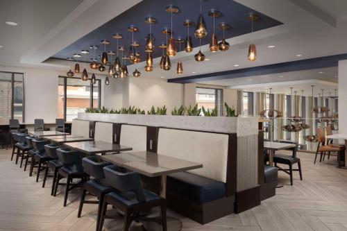 a restaurant with tables and chairs and a bar at Embassy Suites By Hilton Knoxville Downtown in Knoxville