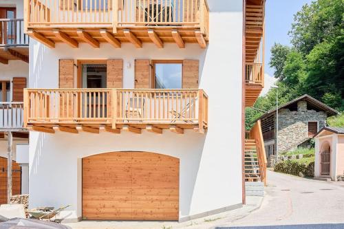 a house with a wooden garage door and a balcony at Ai Masetti di TSS'- Riposo nel Verde, curato, silenzioso in Vignola