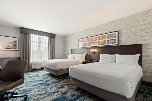 a hotel room with two beds and a chair at Doubletree By Hilton Front Royal Blue Ridge Shadows in Front Royal