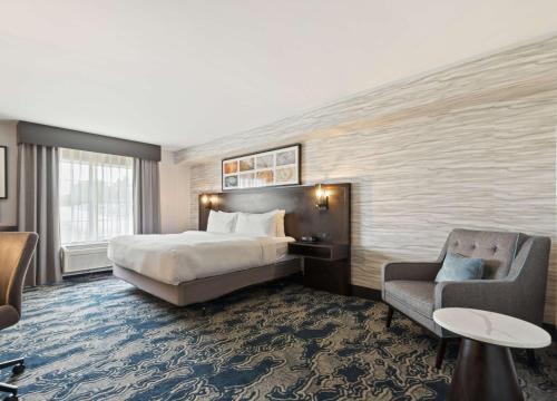 a hotel room with a bed and a chair at Doubletree By Hilton Front Royal Blue Ridge Shadows in Front Royal
