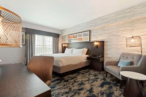 a hotel room with a bed and a desk and chair at Doubletree By Hilton Front Royal Blue Ridge Shadows in Front Royal