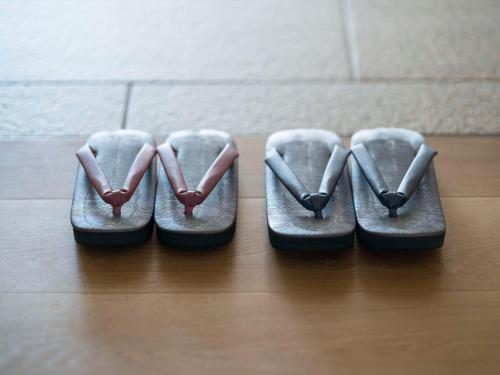 two pairs of shoes sitting on a wooden floor at Banyan Tree Higashiyama Kyoto in Kyoto