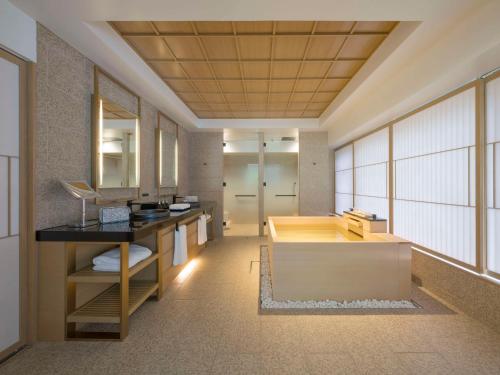 a bathroom with a tub and a sink at Banyan Tree Higashiyama Kyoto in Kyoto