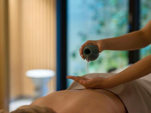 a man getting a massage from a therapist at Banyan Tree Higashiyama Kyoto in Kyoto