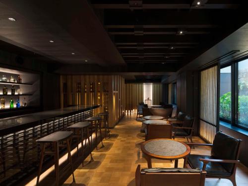 a restaurant with a bar with tables and chairs at Banyan Tree Higashiyama Kyoto in Kyoto