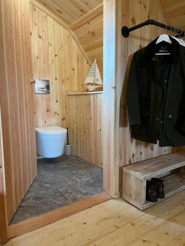 a bathroom with a tub in a wooden cabin at Sandy Meadow Escapes in Achmelvich