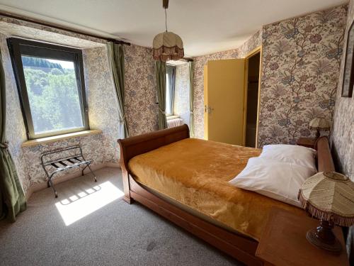 a bedroom with a bed and a window at Gîte-Auberge du Pont de Lanau in Neuvéglise