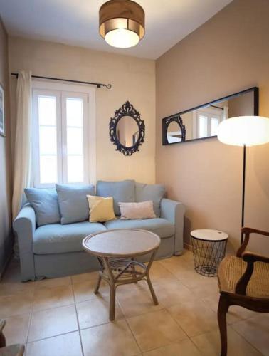 un salon avec un canapé bleu et une table dans l'établissement Les Arènes Quartier La Roquette, à Arles