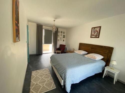 a bedroom with a bed with a blue comforter at Grand T2 indépendant centre ville 1er étage in Saint-Junien