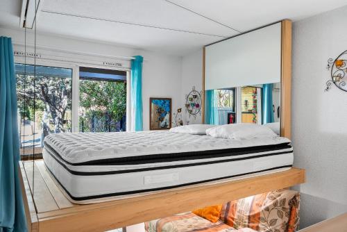 - une chambre avec un lit sur une plate-forme en bois dans l'établissement Beau Studio St Cyr Sur Mer, à Saint-Cyr-sur-Mer