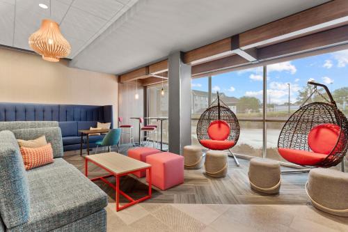 a waiting room with chairs and swings at Tru By Hilton Lincoln East in Lincoln