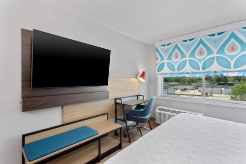 a room with a flat screen tv on a wall at Tru By Hilton Lincoln East in Lincoln