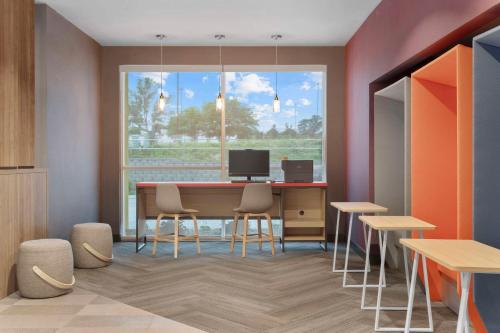 a dining room with a table and chairs and a window at Tru By Hilton Lincoln East in Lincoln