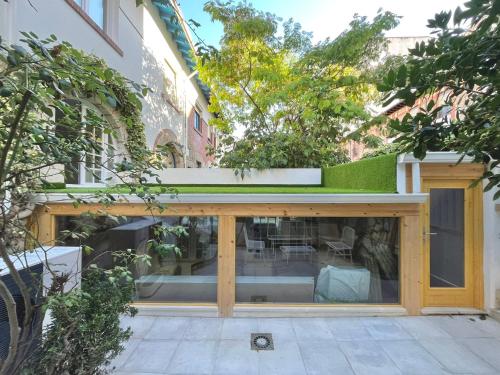 a building with a window with a green roof at El Jardín de María Luisa Suites in Burgos