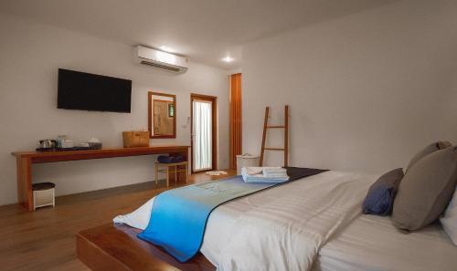 a bedroom with a large bed with a tv on the wall at Sichon Cabana Beach Resort in Sichon